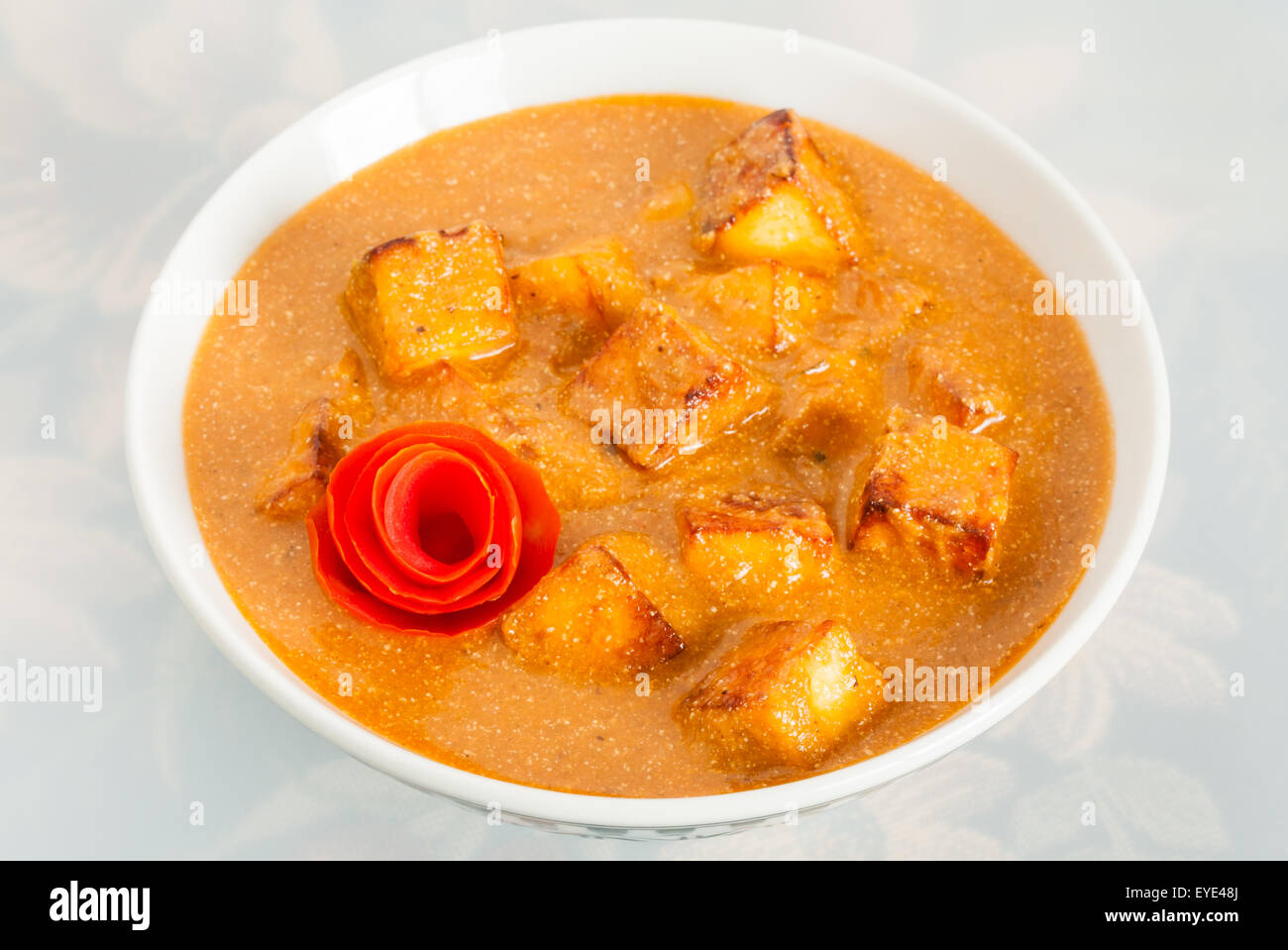 Closeup of delicious Indian paneer butter masala garnished with tomato peel. It is prepared using paneer (cottage cheese). Stock Photo