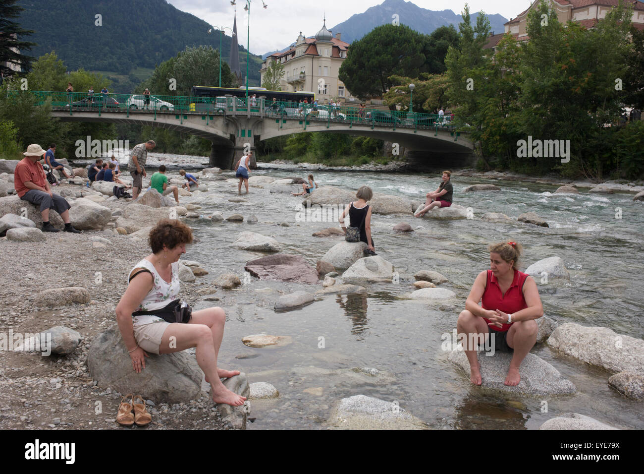 Locals bathe in the Passer River, in the South Tyrolean town of Meran-Merano, best known for its spa resorts, located within a basin, surrounded by mountains standing up to 3,335 metres (10,942 feet) above sea level, at the entrance to the Passeier Valley and the Vinschgau. In the past, the town has been a popular place of residence for several scientists, literary people, and artists, including Franz Kafka, Ezra Pound, and Paul Lazarsfeld, who appreciated its mild climate. Stock Photo