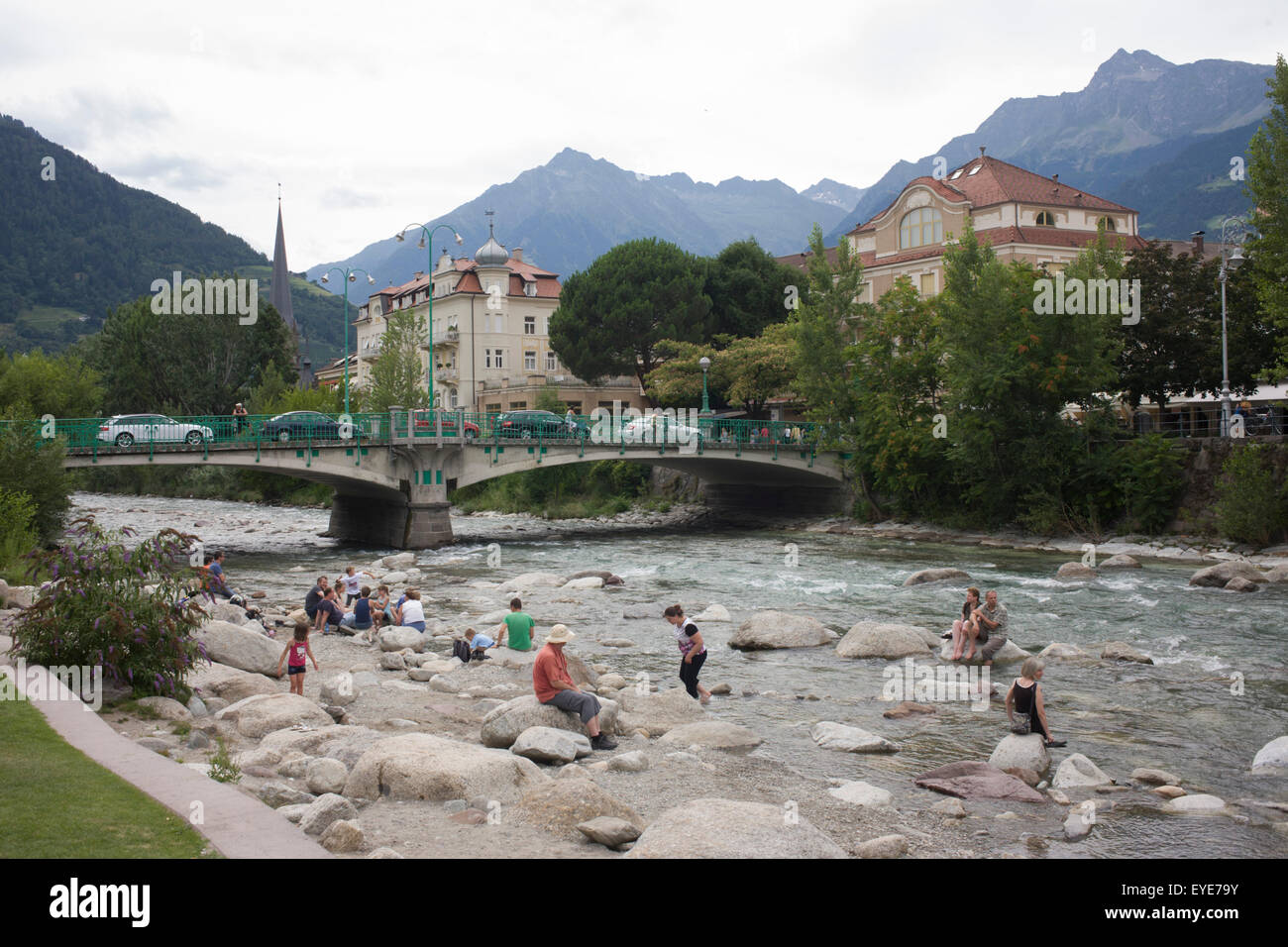 Locals bathe in the Passer River, in the South Tyrolean town of Meran-Merano, best known for its spa resorts, located within a basin, surrounded by mountains standing up to 3,335 metres (10,942 feet) above sea level, at the entrance to the Passeier Valley and the Vinschgau. In the past, the town has been a popular place of residence for several scientists, literary people, and artists, including Franz Kafka, Ezra Pound, and Paul Lazarsfeld, who appreciated its mild climate. Stock Photo