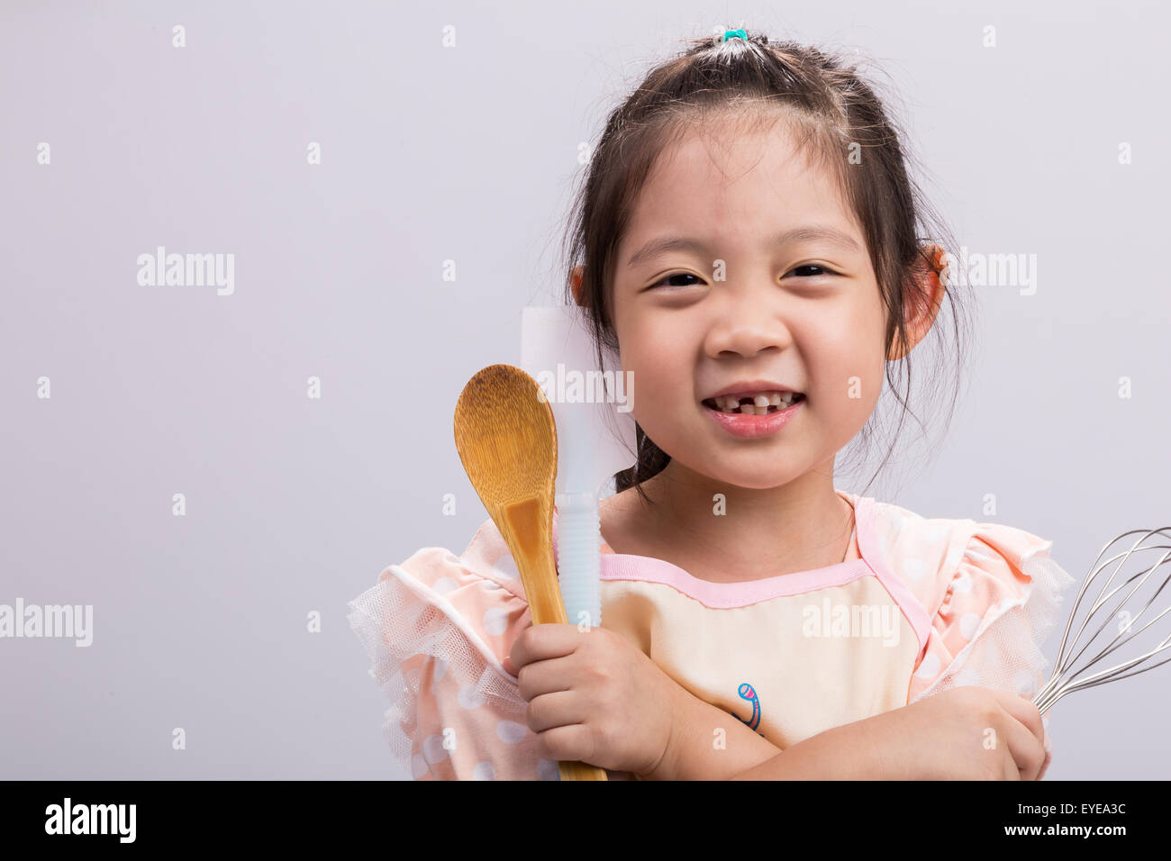 Happy little girl holding kitchenware in her hands Stock Photo - Alamy