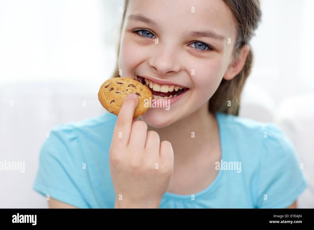 smiling little girl eating cookie or biscuit Stock Photo Alamy