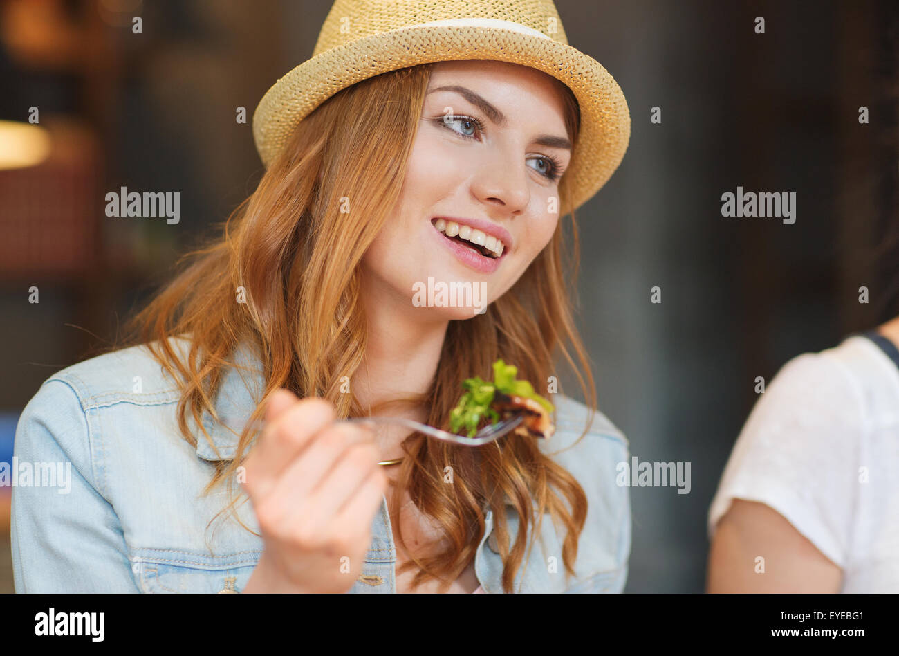 happy young woman eating salad at bar or pub Stock Photo