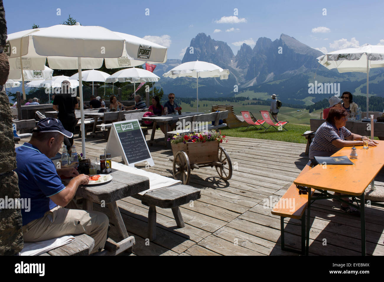Refuge hut terrace lunches on the Siusi plateau, above the South Tyrolean town of Ortisei-Sankt Ulrich in the Dolomites, Italy. Stock Photo