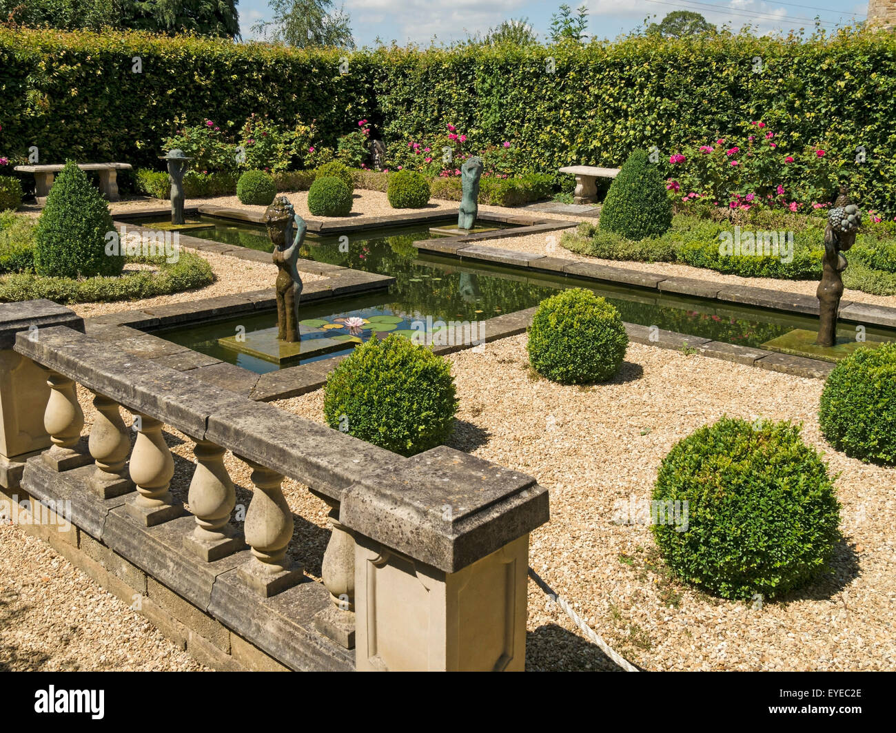 Small, formal, landscaped water garden, with sculptures by Lily Sawtell. Barnsdale Gardens, Rutland, England, UK. Stock Photo