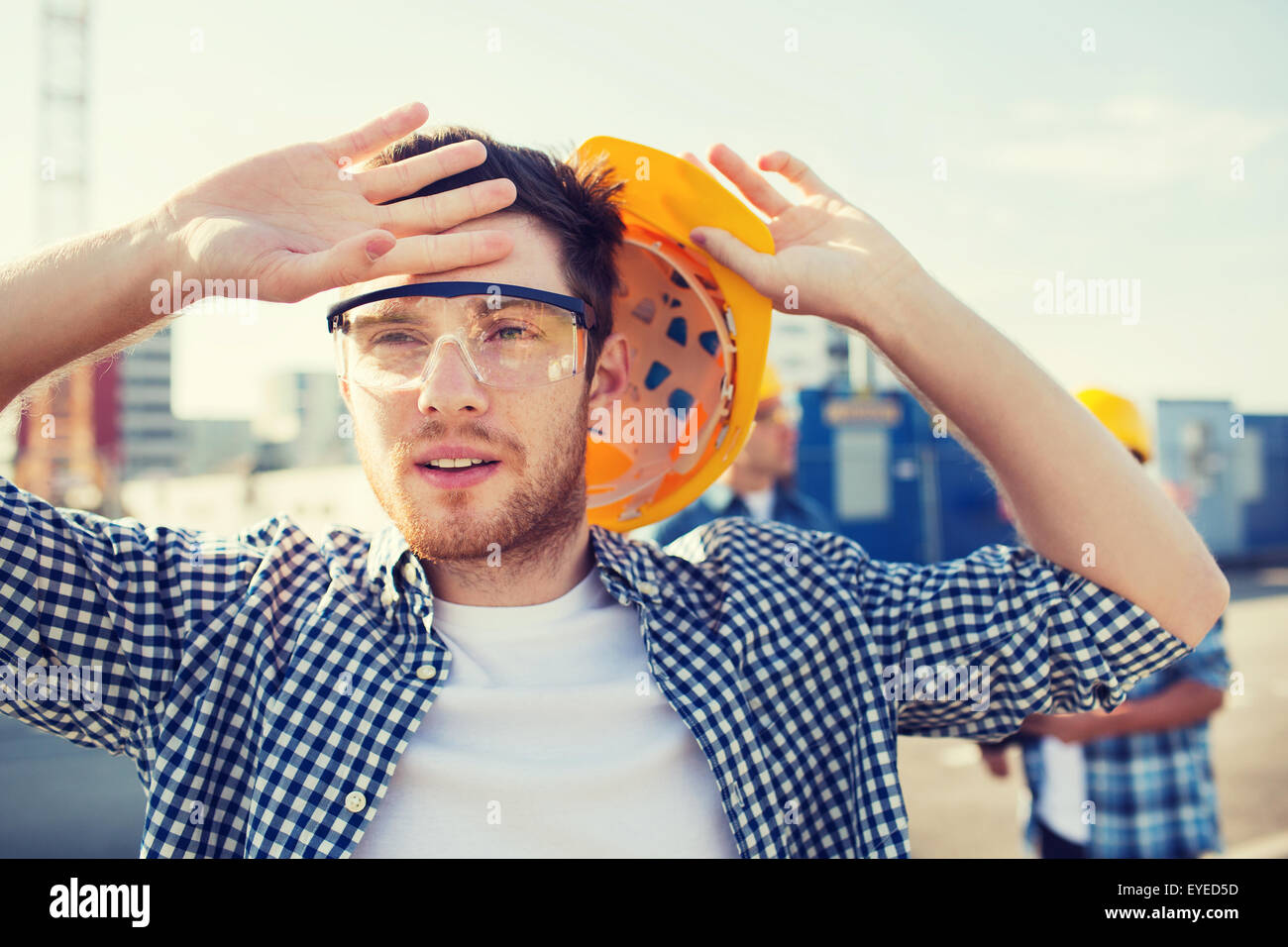 group of builders in hardhats outdoors Stock Photo