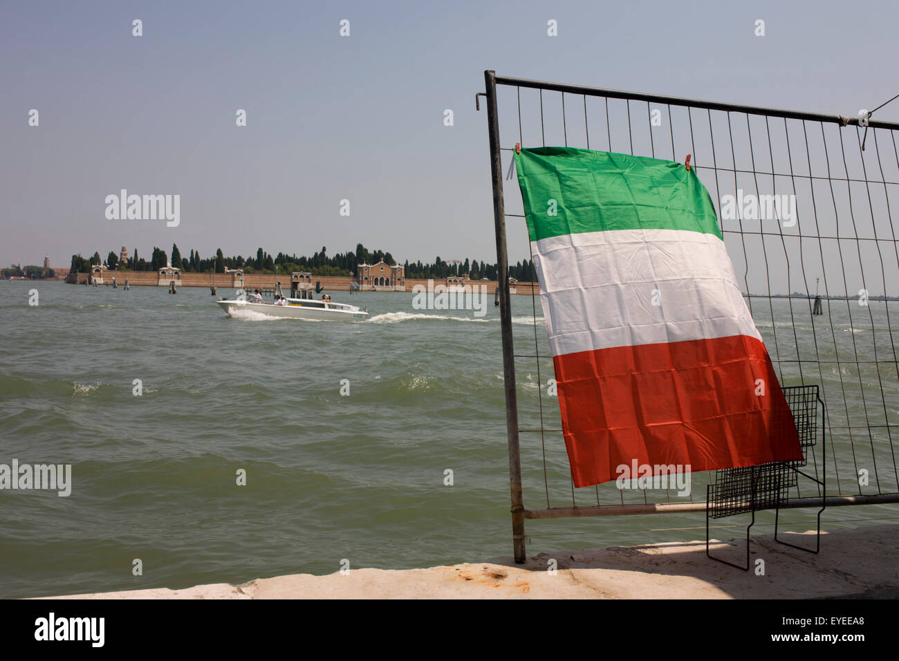A speedboat passes the Italian flag on Venice's Canale delle Fondamenta Nuove in the Cannaregio district. Stock Photo
