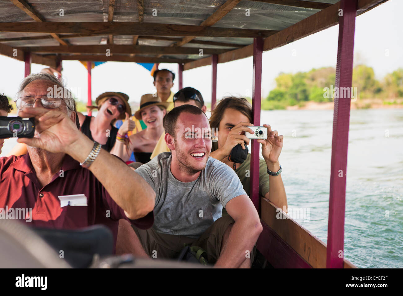 Tourists take a ferry on the Mekong River to the Island of Don Det; Laos Stock Photo