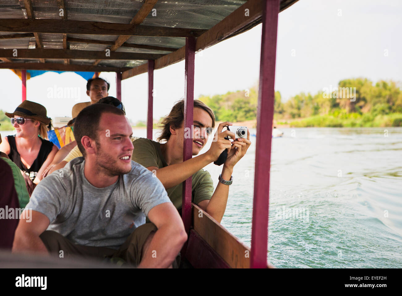 Tourists take a ferry on the Mekong River to the Island of Don Det; Laos Stock Photo