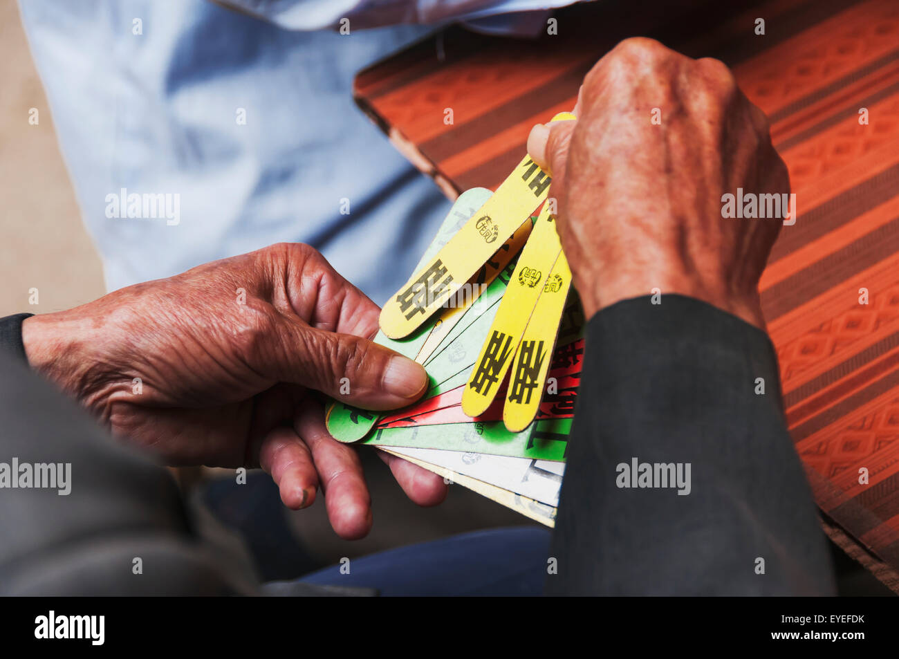 Detail of hands of a old man playing traditional Chinese cards; Yongding, Fujian province, China Stock Photo