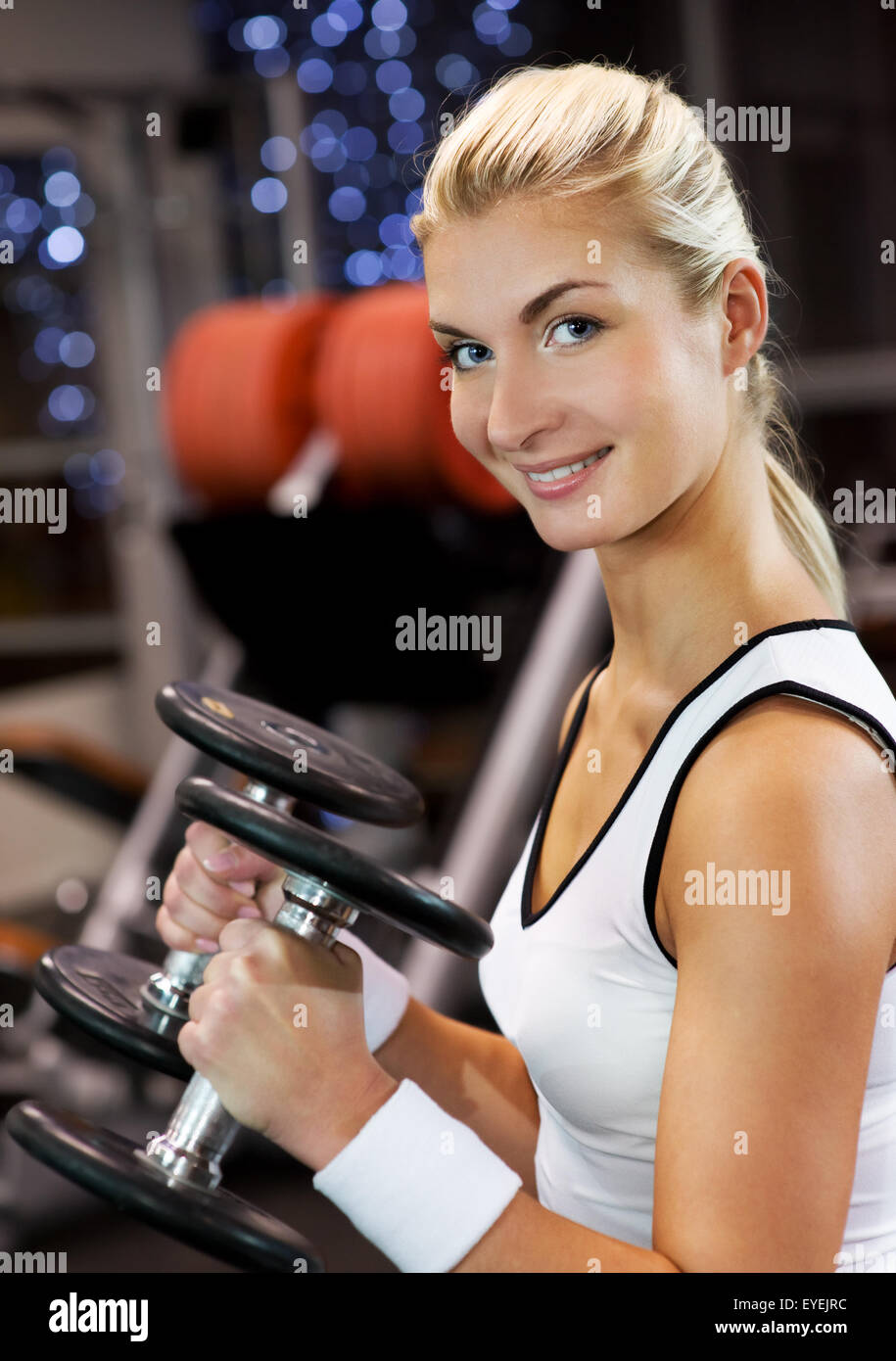 Strong beautiful woman lifting heavy dumbbells Stock Photo Alamy