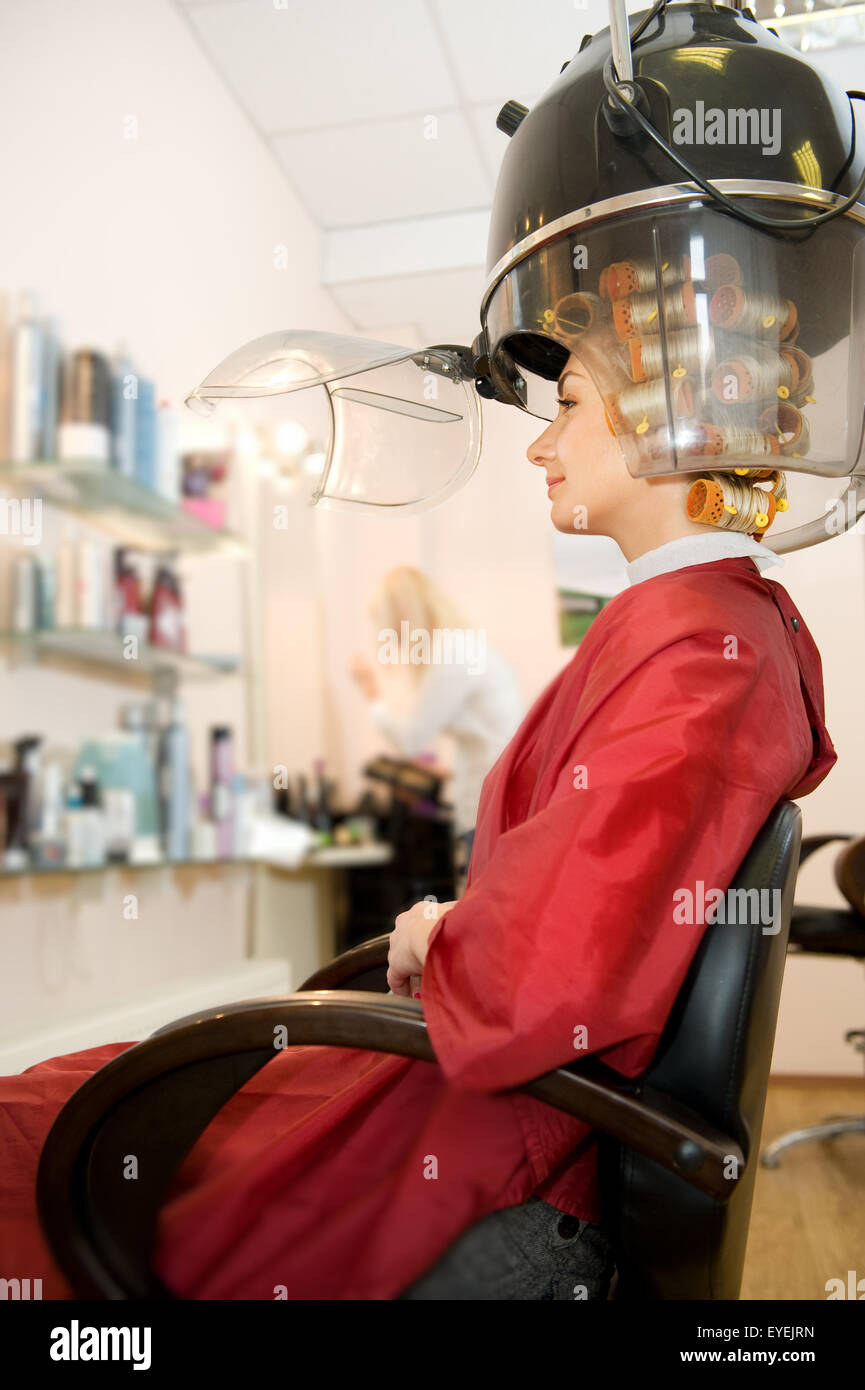 Young woman drying her hair in beauty salon Stock Photo - Alamy