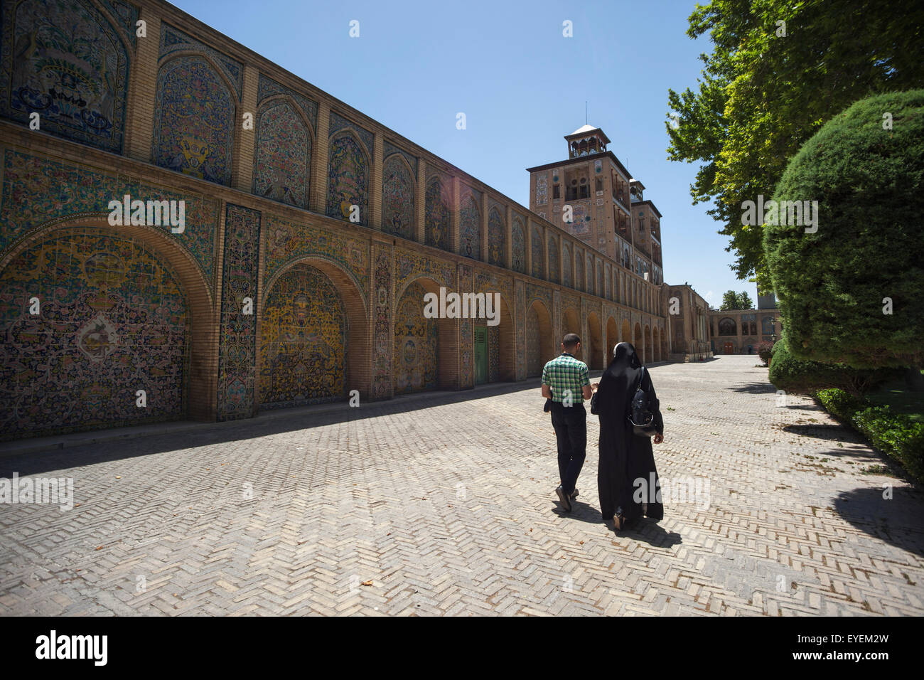 Iranian couple walking towards The Edifice of the Sun (Shams ol Emareh), Golestan Palace; Tehran, Iran Stock Photo