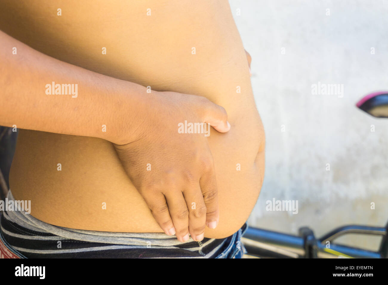 Fat man holding at his tummy, Fat man with a big belly Stock Photo - Alamy