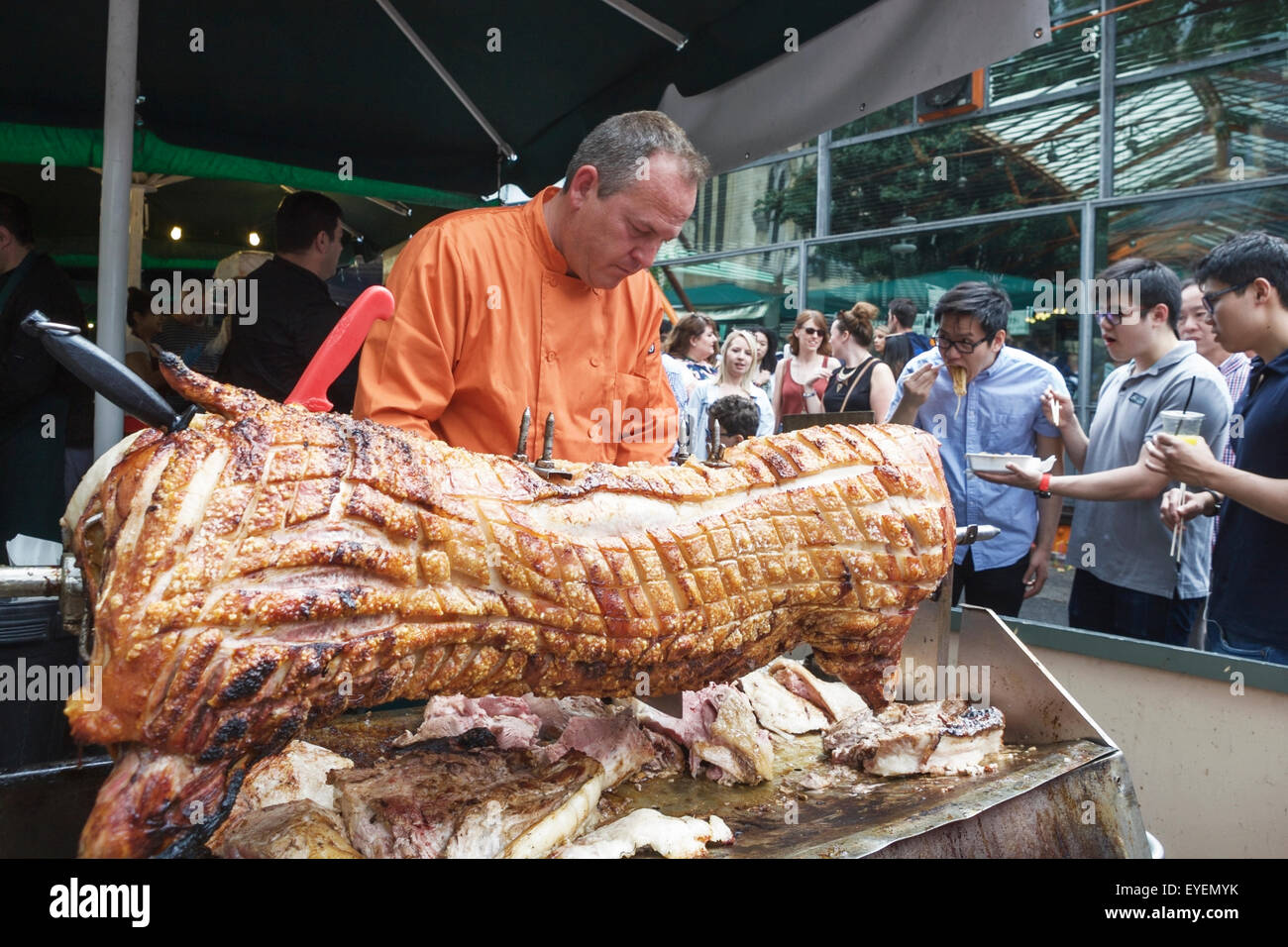 Borough Market London, food seller, roast hog, and potential customers. Stock Photo