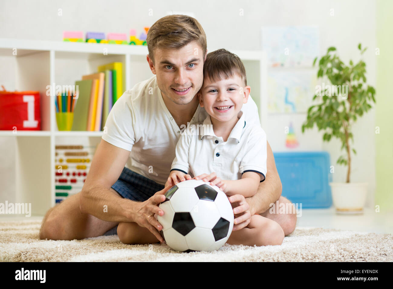 child boy with dad play football at home Stock Photo