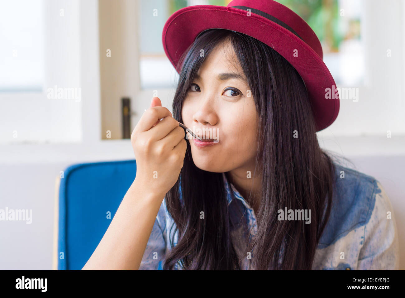 Smiling young asian woman eating cake in bakery shop, Smiling and look