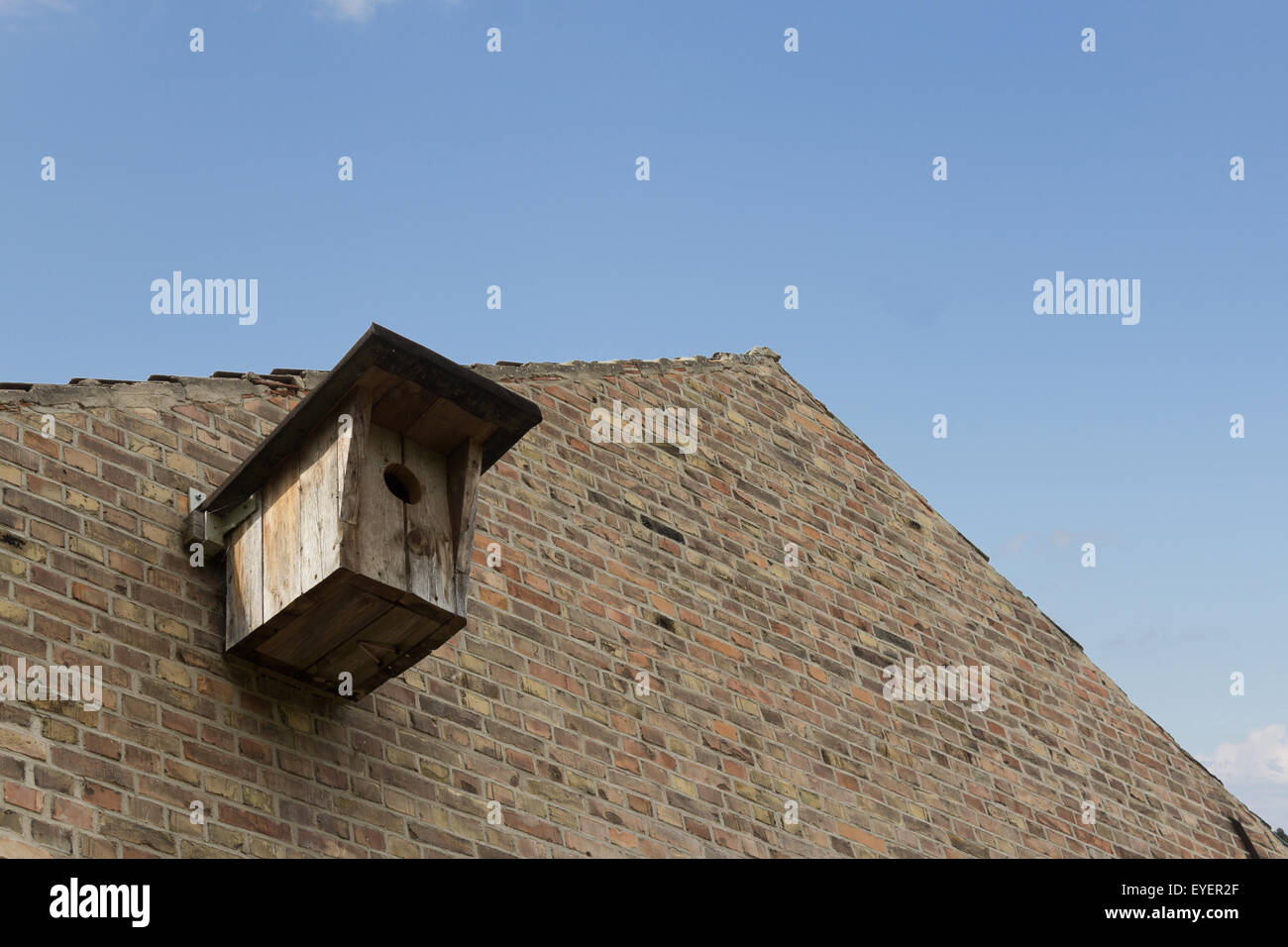 wooden birdhouse on building facade / bird house Stock Photo