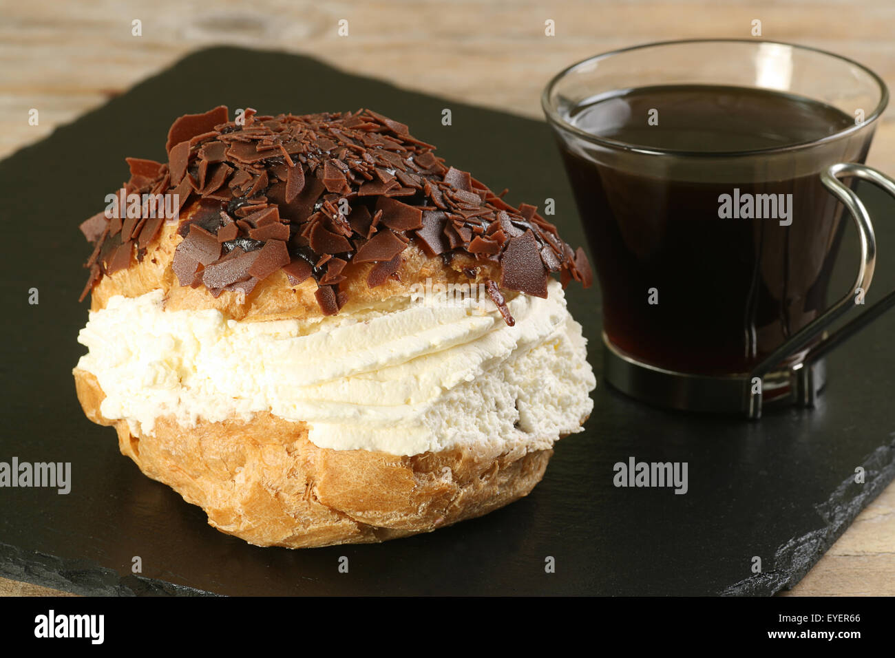 cream filled chocolate choux bun with black coffee Stock Photo
