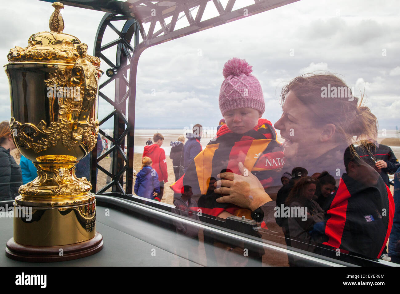 Crosby, Liverpool. Merseyside, UK.  28th July, 2015.  Leah Holland 1 year old, in a Southport Rugby Club shirt, & Lauren McCluskey at the Rugby World Cup Trophy Tour promotional event held on Crosby Beach. The Webb Ellis Cup was displayed in Windle to mark England's hosting of the tournament later this year. More than 250 local youngsters represented every team in the World Cup as Liverpool St Helens, the oldest open rugby club in the world, hosted  its own mini-tournament to mark the trophy's visit. Stock Photo