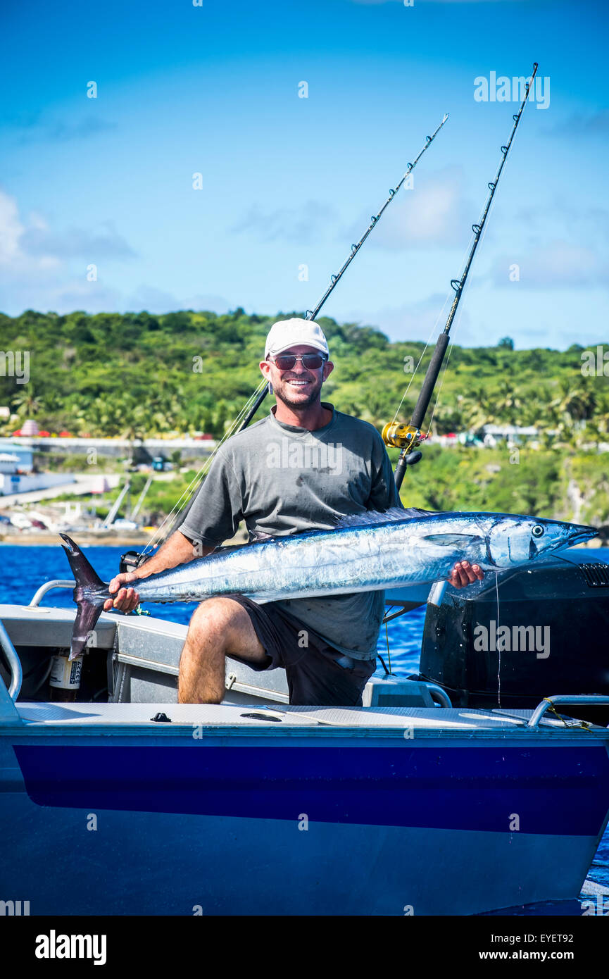 Proud fisherman showing his catch with Niue Island in the background; Niue Stock Photo