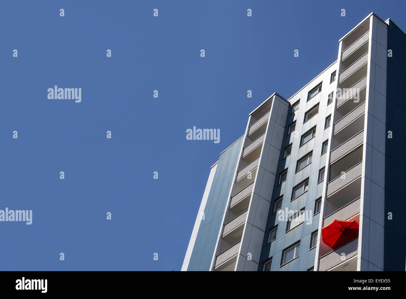 blue residential building berlin germany,blue sky and red umbrella on balcony Stock Photo