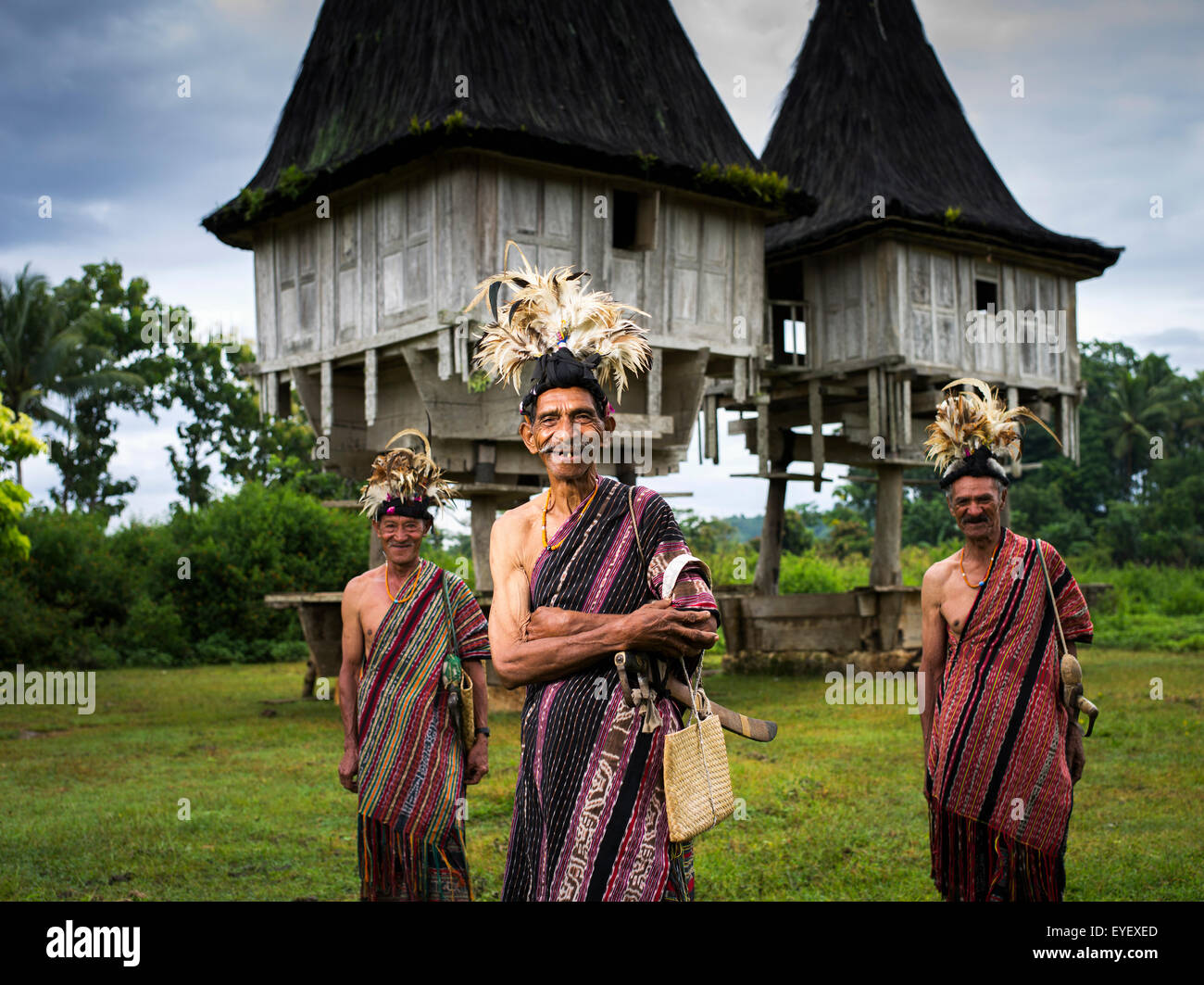 Elderly men in traditional attire standing in front of distinctive