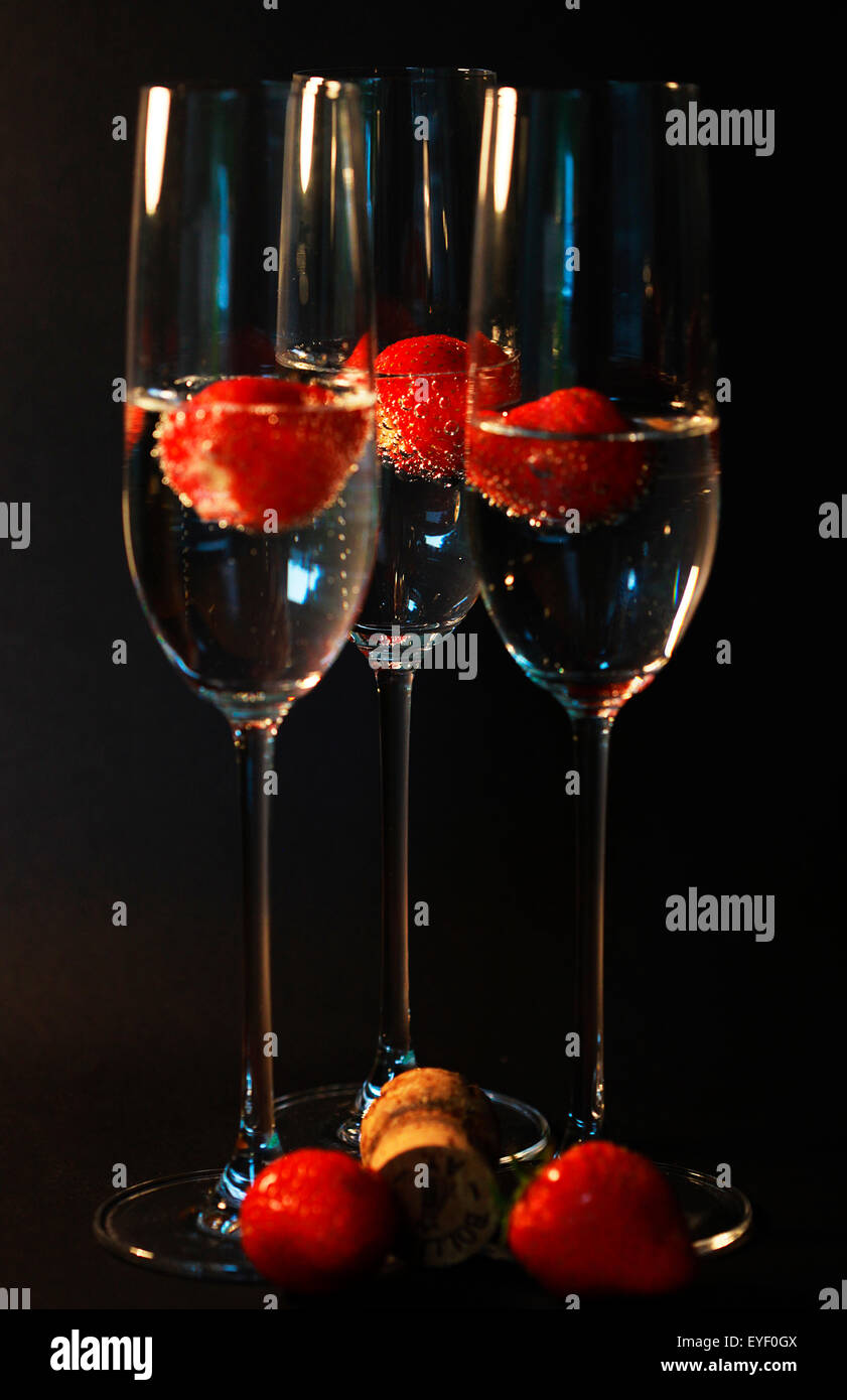 Three glasses of champagne cocktails against a black backdrop Stock Photo