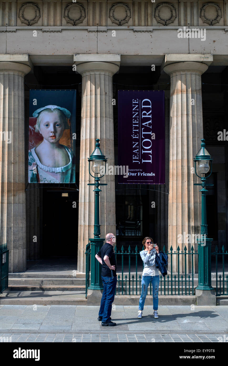 Tourists taking photographs outside the Royal Scottish Academy building with banner for the Jean-Étienne Liotard Exhibition in 2015. Stock Photo