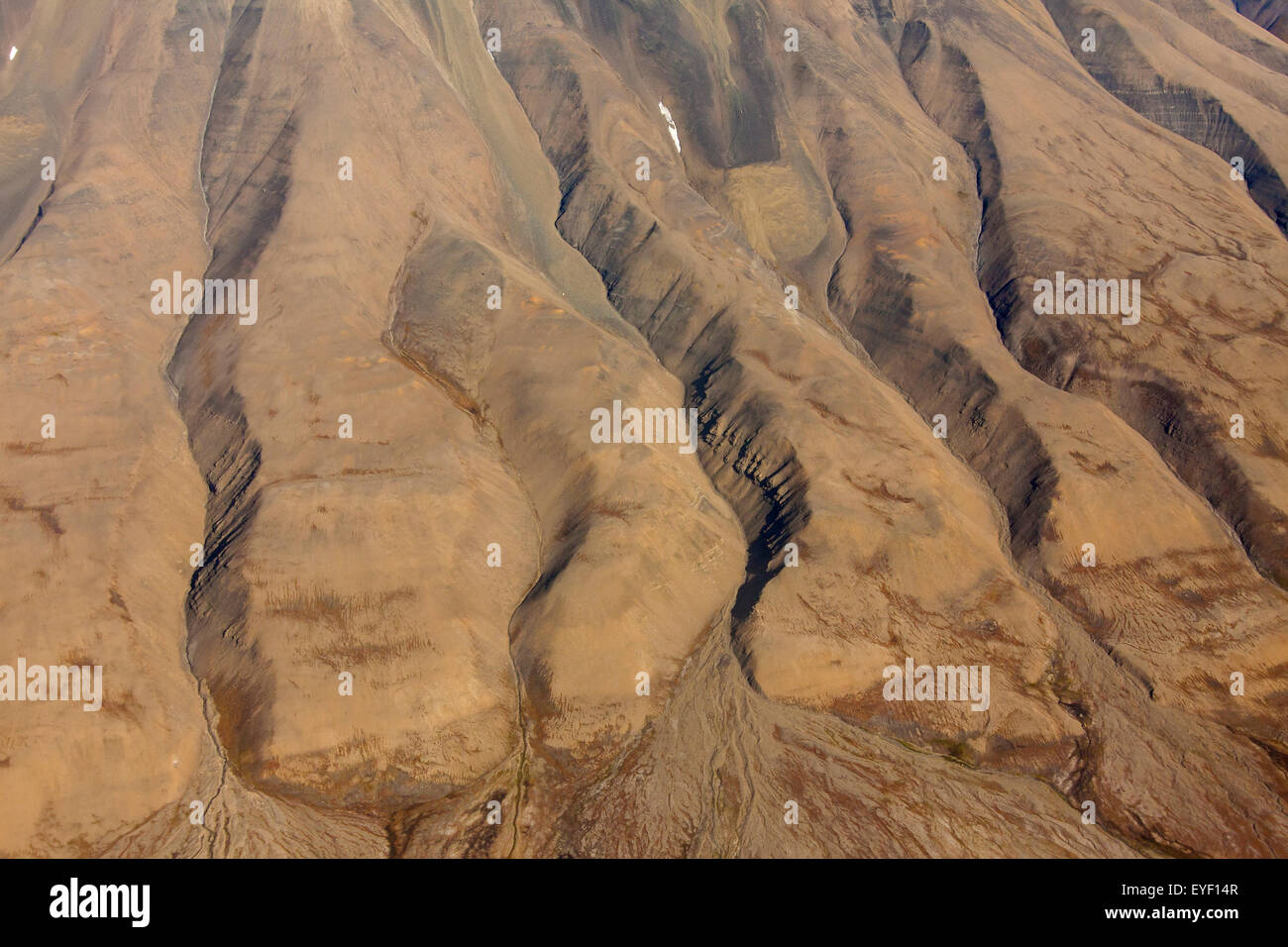 Aerial view of barren mountainside with deep gullies carved by water erosion at Spitsbergen / Svalbard, Norway Stock Photo