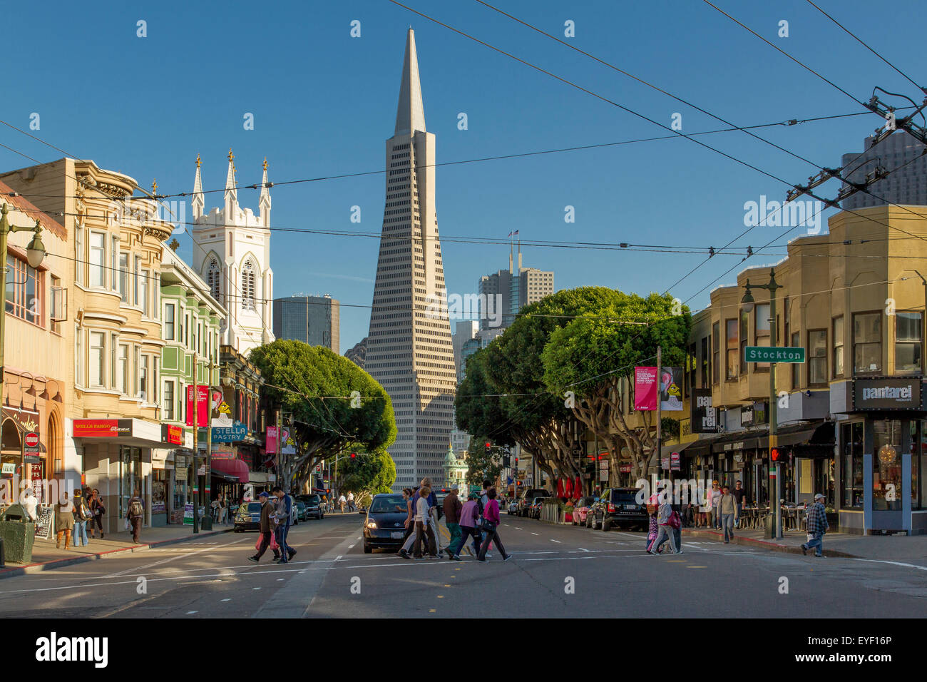 People crossing Columbus Avenue,in The North Beach area Of San Francisco,with The Transamerica Building in the background,San Francisco,California,USA Stock Photo