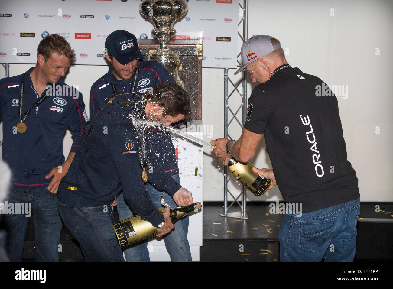 As he struggles to open his bottle, Sir Ben Ainslie is sprayed in the face with champagne by sailing rival Jimmy Spithill Stock Photo