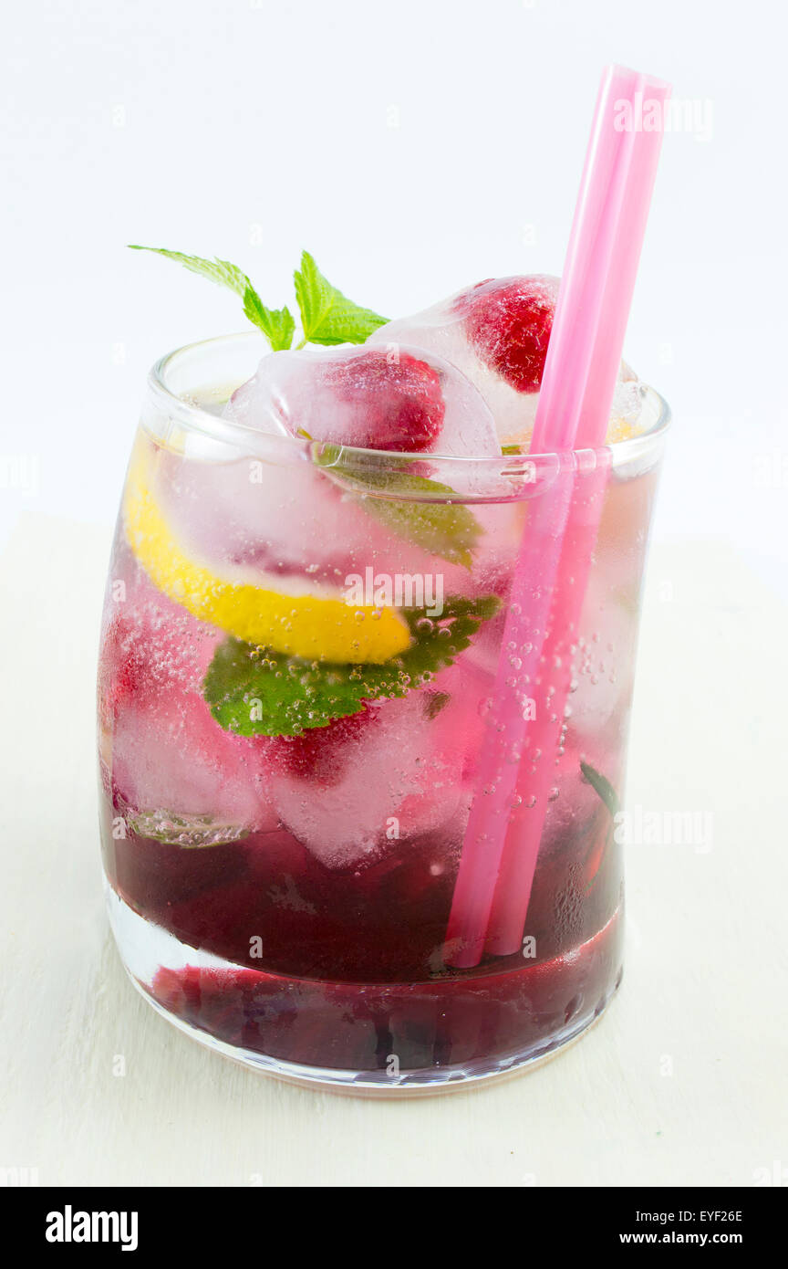 Natural homemade red forest fruit iced-T juice with ice, lemon and sliced fruits Stock Photo