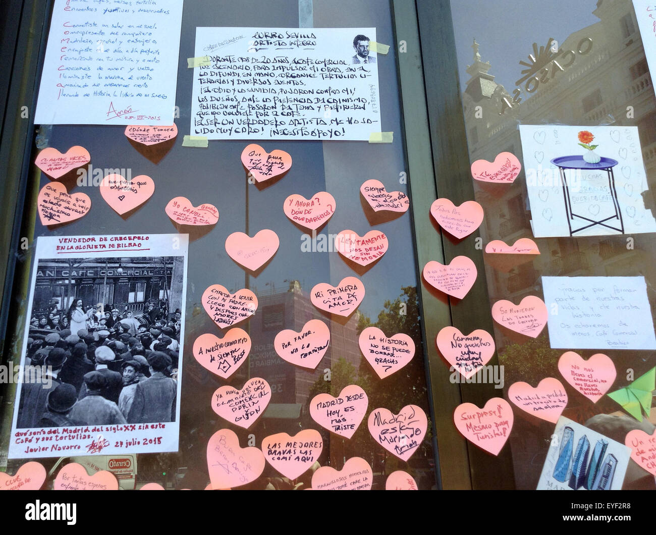 Madrid, Spain. 28th July, 2015. Small notes stuck on a glass panel of Cafe Comercial following its unannounced closure after more than 128 years in Madrid, Spain, 28 July 2015. Messages left on the heart-shaped notes include 'I had my first date here', 'Don't take away our history' and 'Madrid is a little sadder today.' Local residents are protesting the sudden closure of the famous and popular street cafe through declarations of love and demands to keep the business alive. Photo: Emilio Rappold/dpa/Alamy Live News Stock Photo