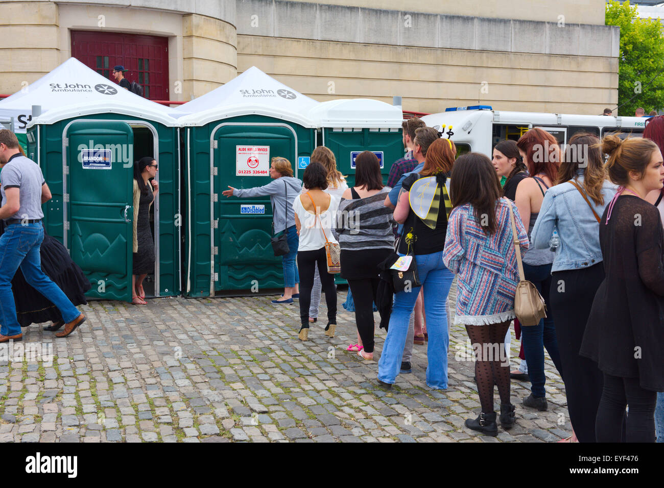 Queue at portable toilets during festival Stock Photo