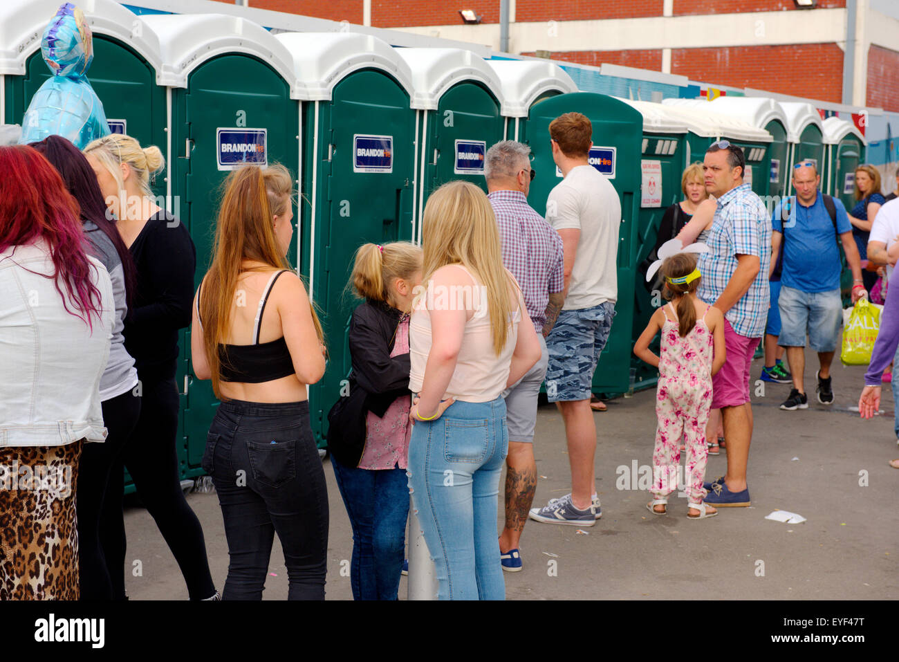 Queue at portable toilets during festival Stock Photo