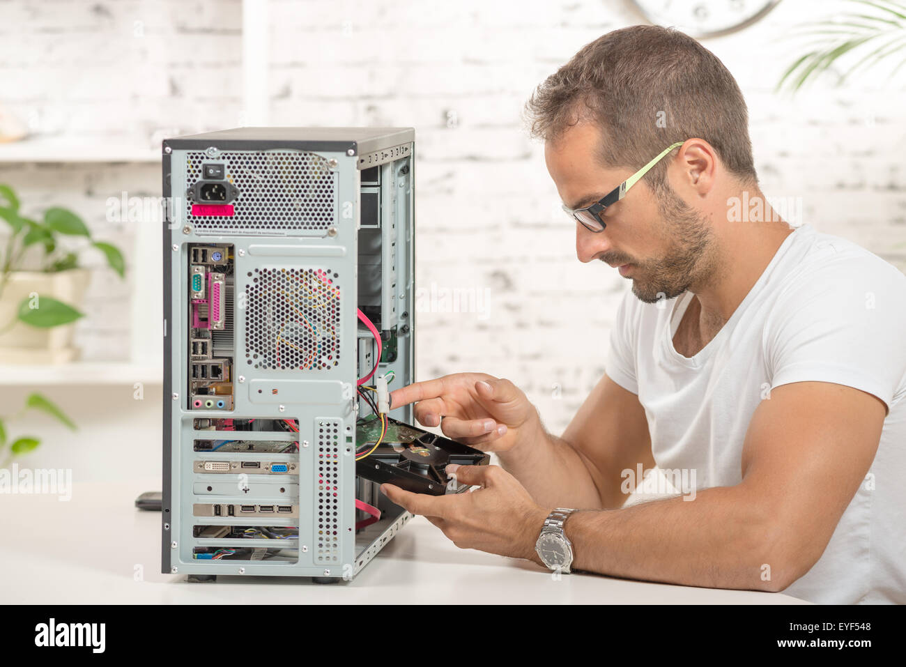 young engineer repaired a computer with a new hard disk Stock Photo - Alamy