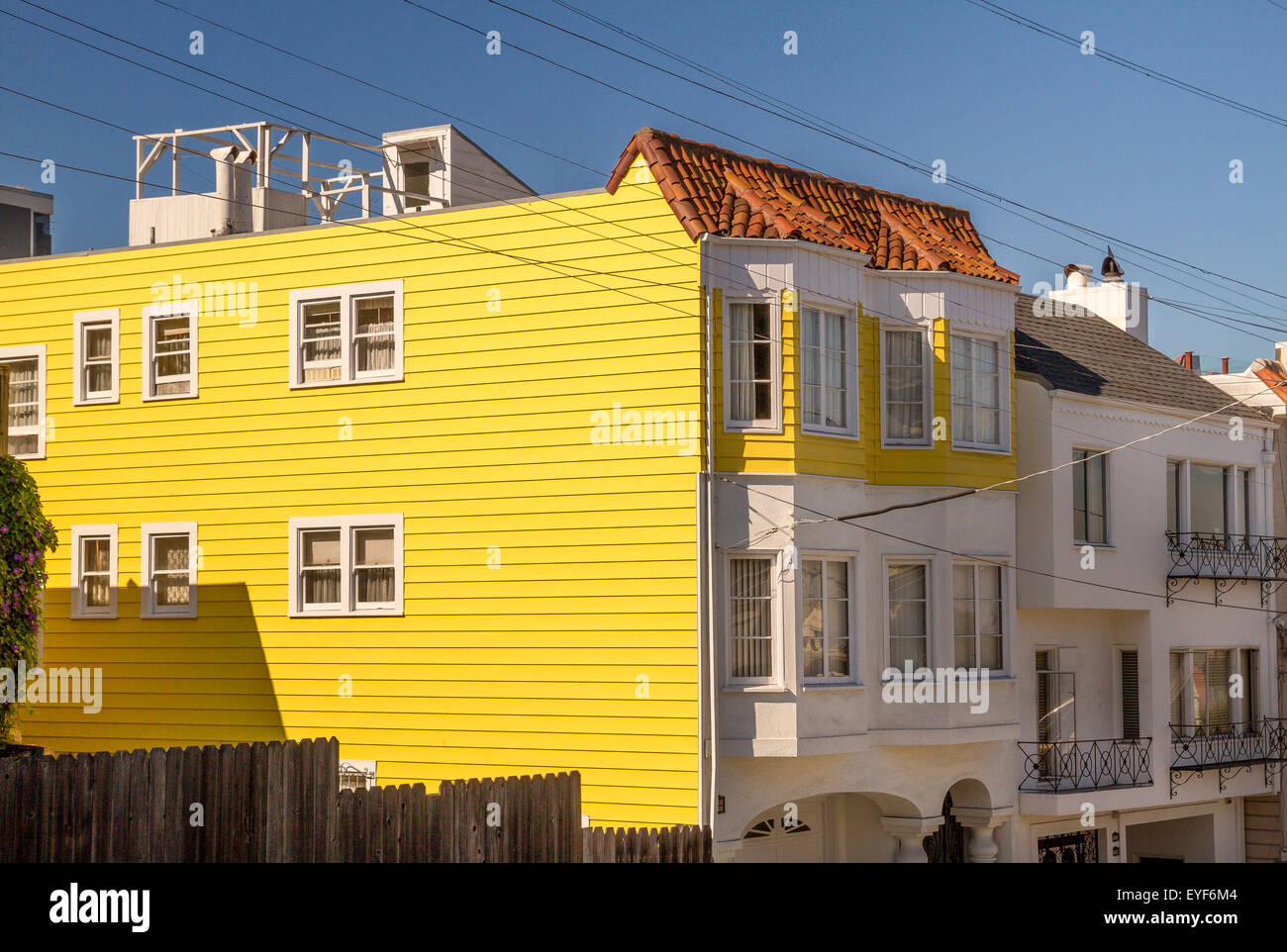 A bright yellow and white clap board house with bay windows near Russian Hill in San Francisco , California ,USA Stock Photo