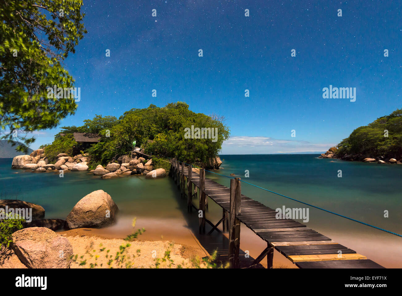 Small bridge going from Mumbo Island to small island for tourist's accommodation under a starry sky, Lake Malawi; Malawi Stock Photo