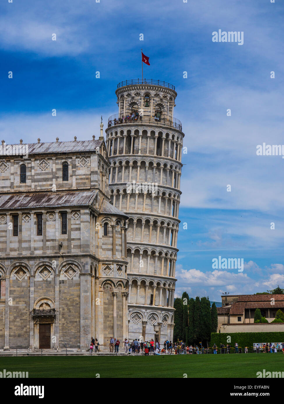 The Leaning Tower of Pisa peaks out from behind the Cathedral at the Piazza del Duomo; Pisa, Italy Stock Photo