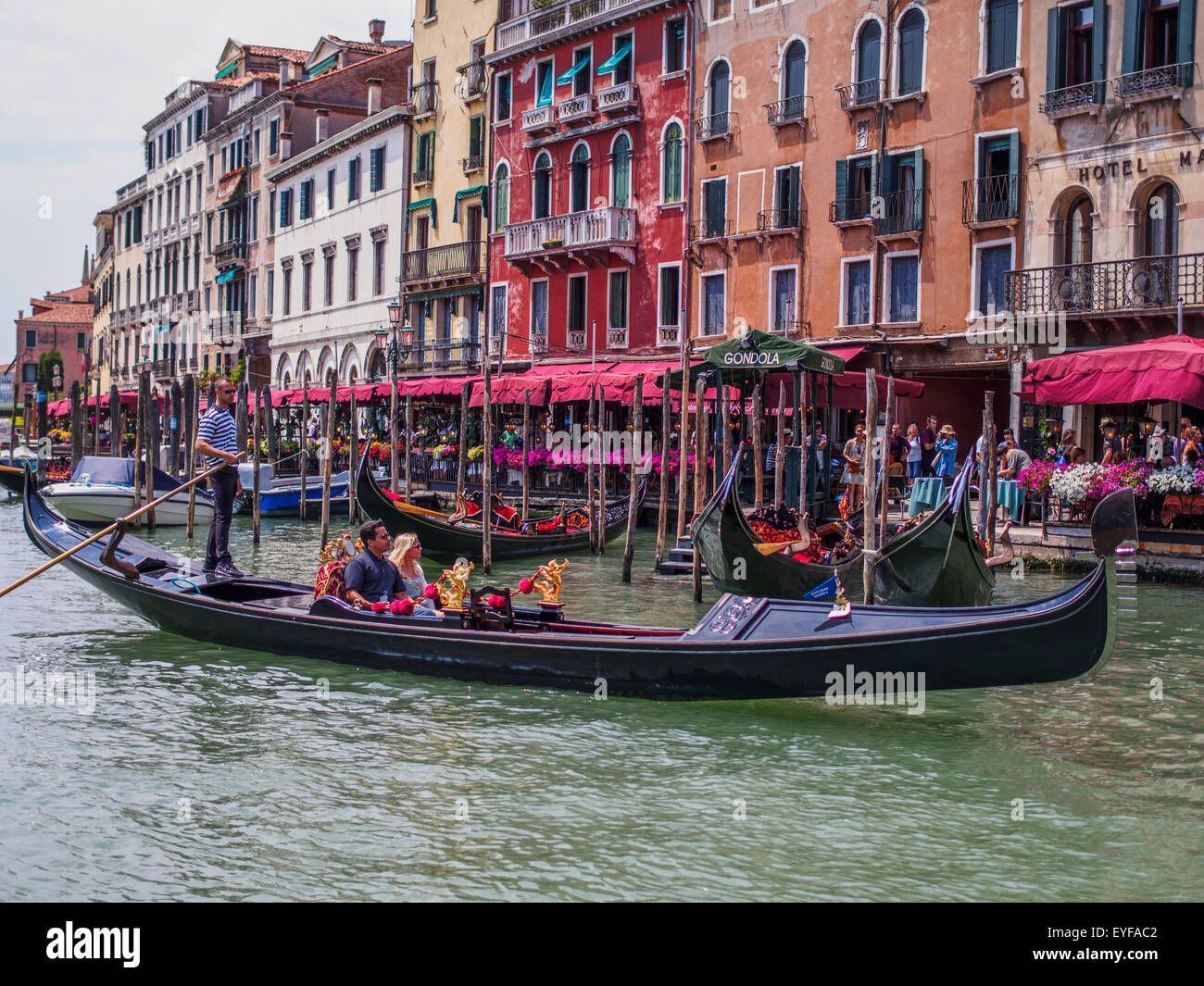 A gondolier maneuvers his gondola on the Grand Canal; Venice, Italy Stock Photo
