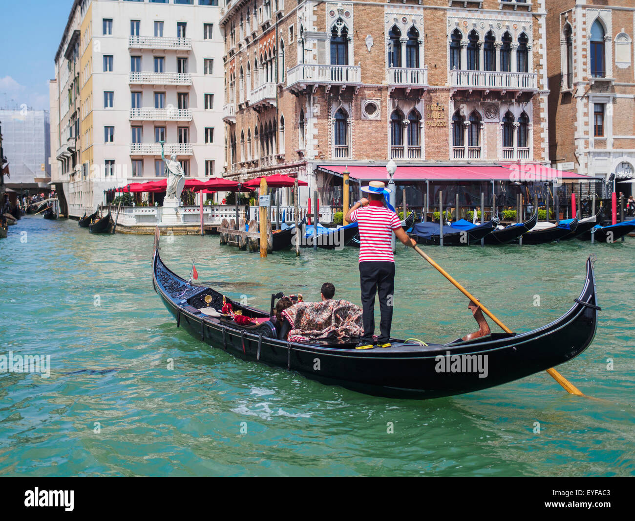 A gondolier maneuvers his gondola on the Grand Canal; Venice, Italy Stock Photo