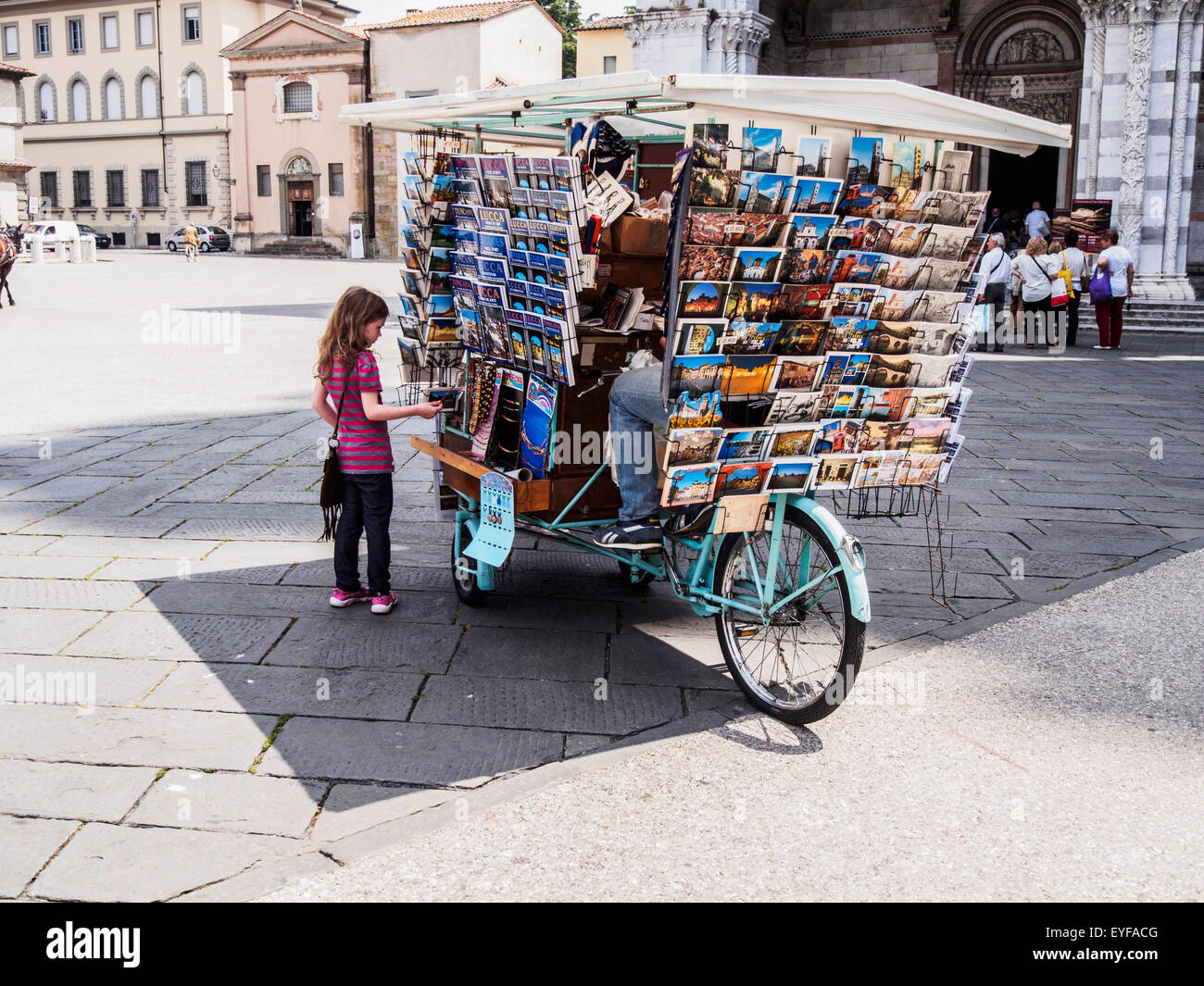 A young girl shops for postcards in Piazza San Michele in the walled city of Lucca; Lucca, Italy Stock Photo