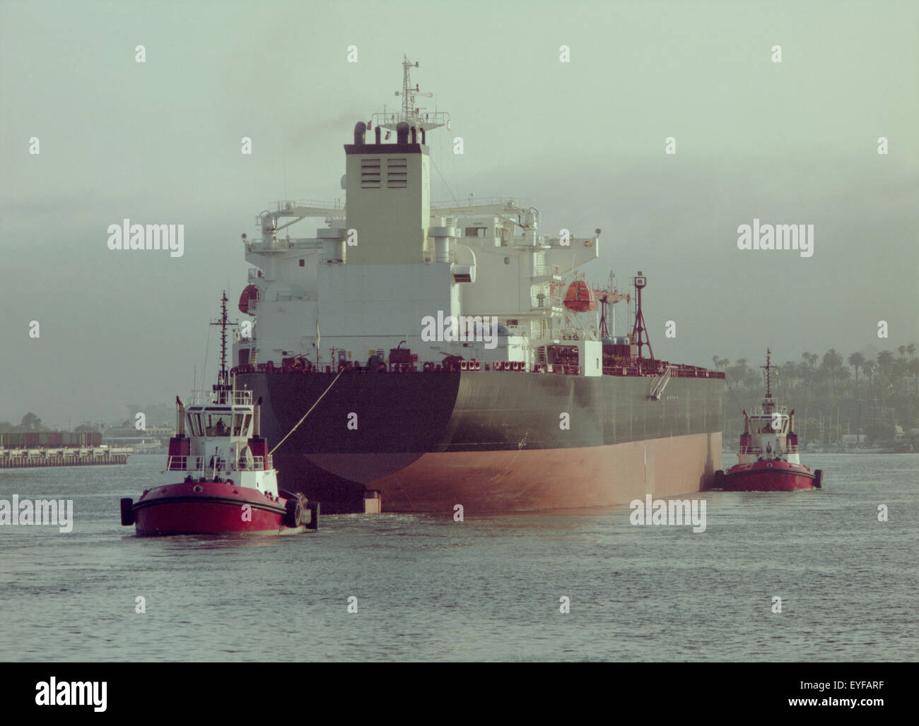 bulk ship with tug assist Stock Photo