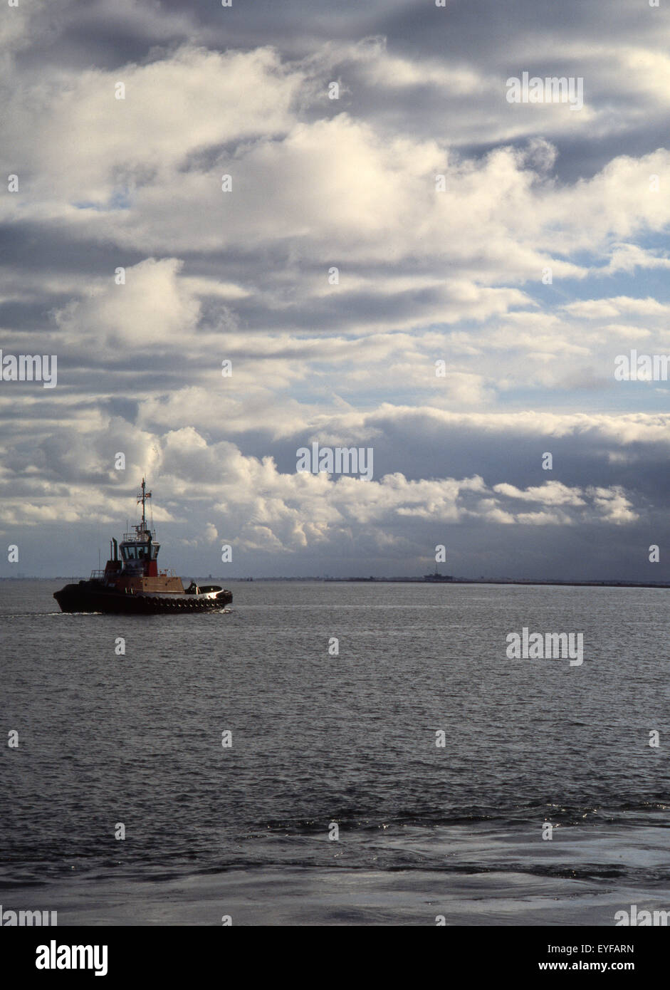 tug boat awaiting a ship with dramatic sky Stock Photo