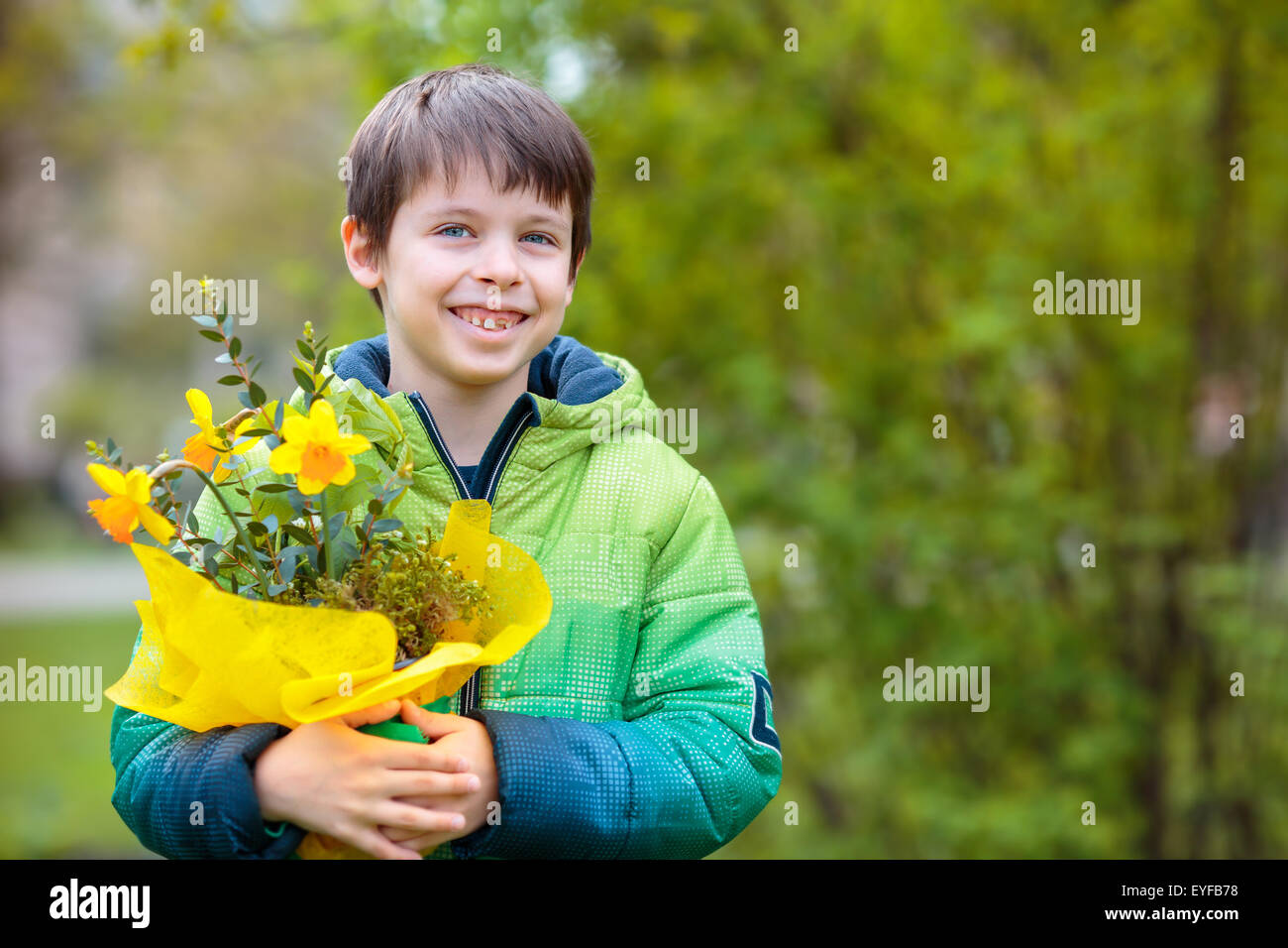 Cute smiling boy holding daffodils Stock Photo