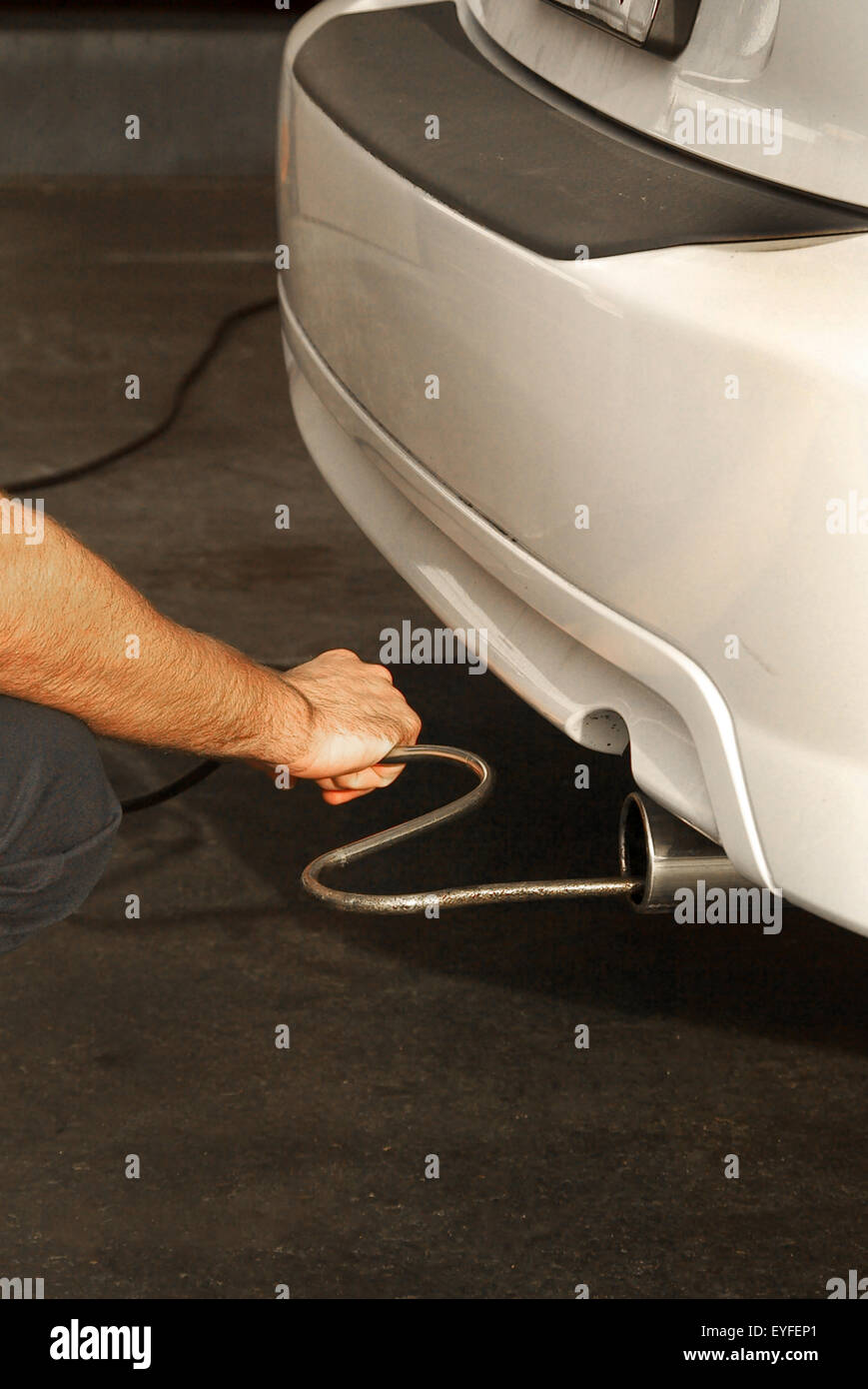 An exhaust pipe electronic probe monitors automobile emissions during a legally required Southern California smog test. Stock Photo