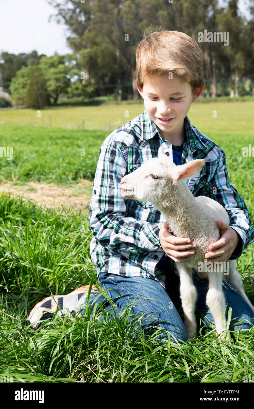 Boy (10-11) holding lamb Stock Photo