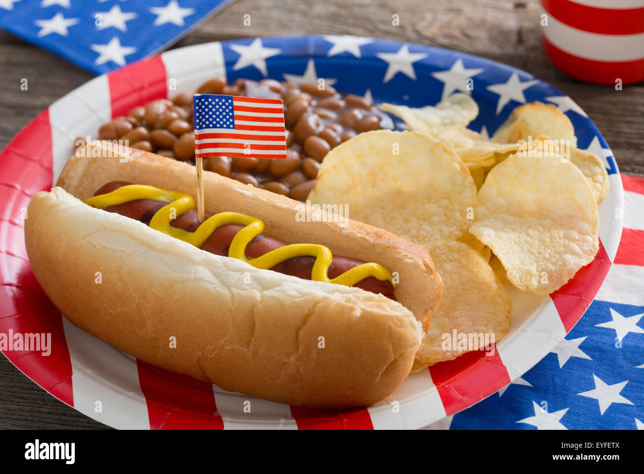 Hot-dog served with beans and chips on USA plate Stock Photo