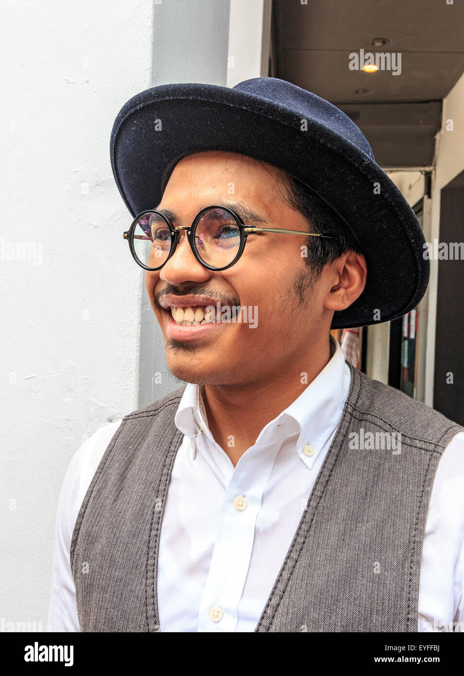 Local waiter, dressed in common clothing for modern Indians living in Singapore, who works in a cafe in Singapore's Little India Stock Photo