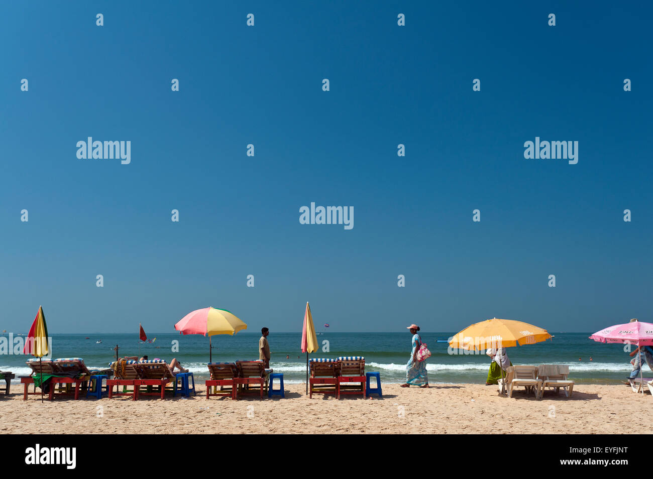 Umbrellas and chairs on a beach at the water's edge; Baga, Goa, India ...